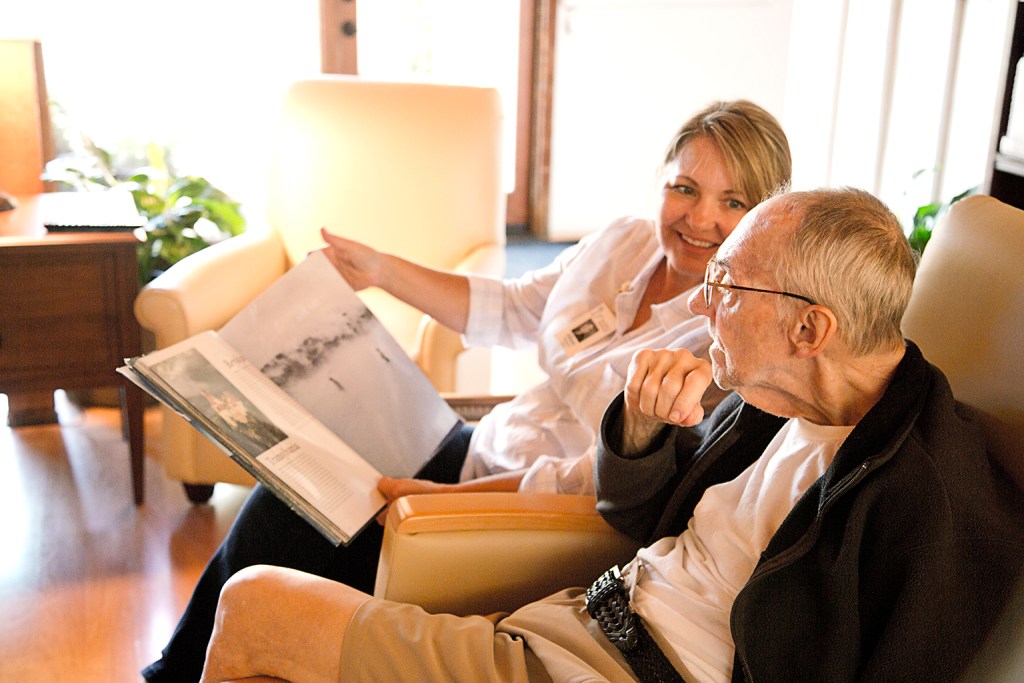 Nurse offers companionship by reading book to patient